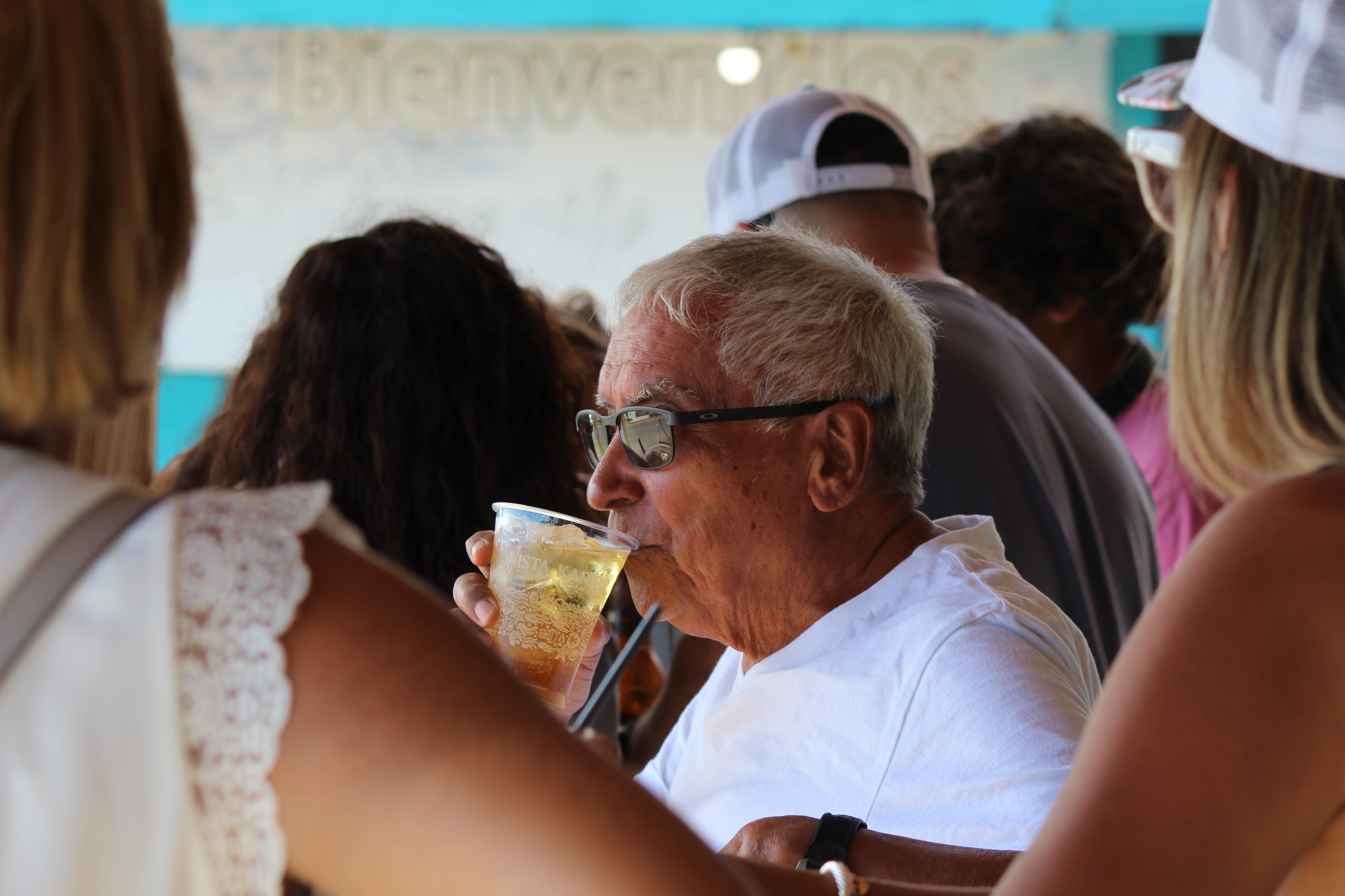 Elderly man drinking from clear cup