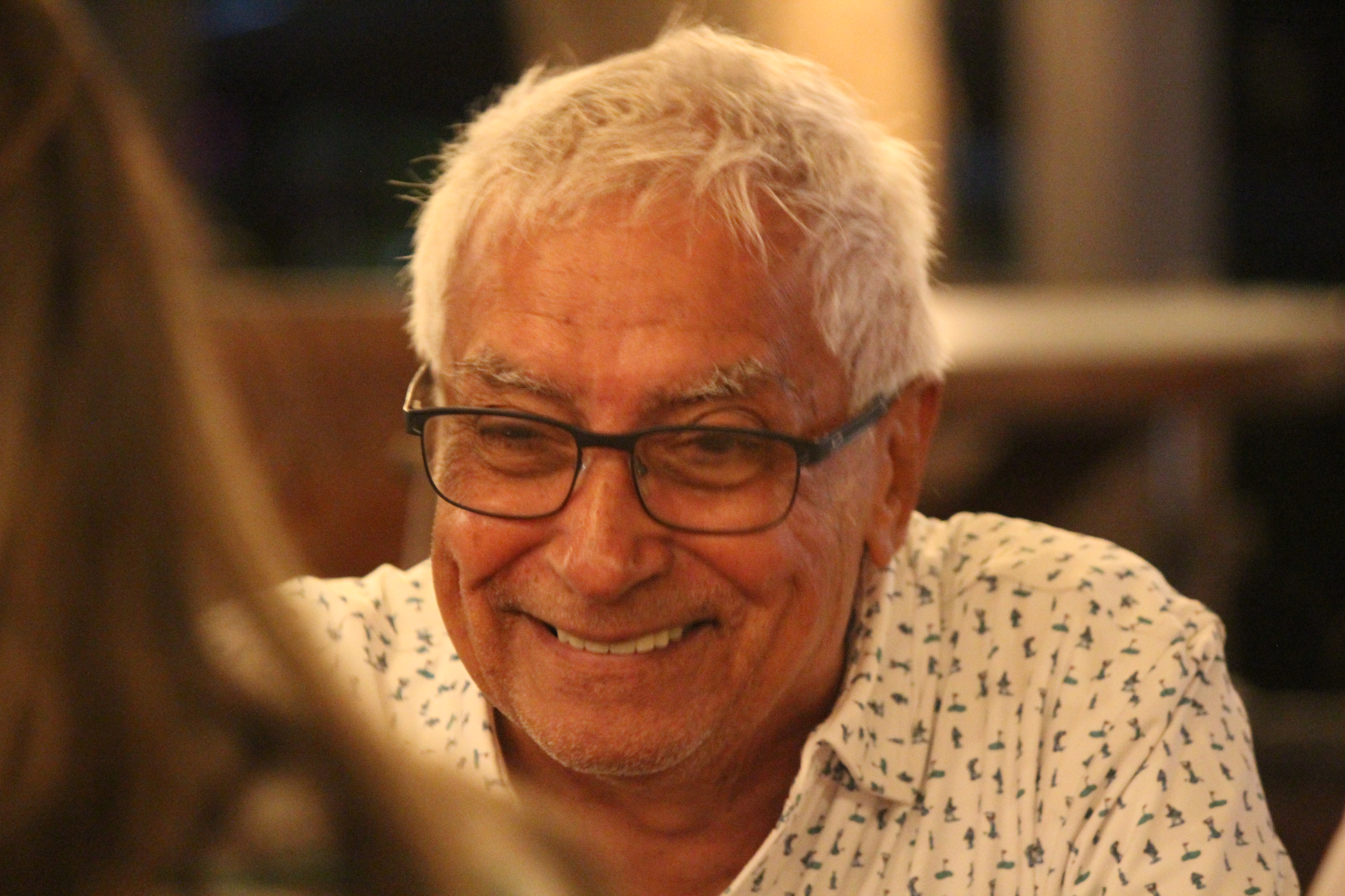 Elderly man smiling at table